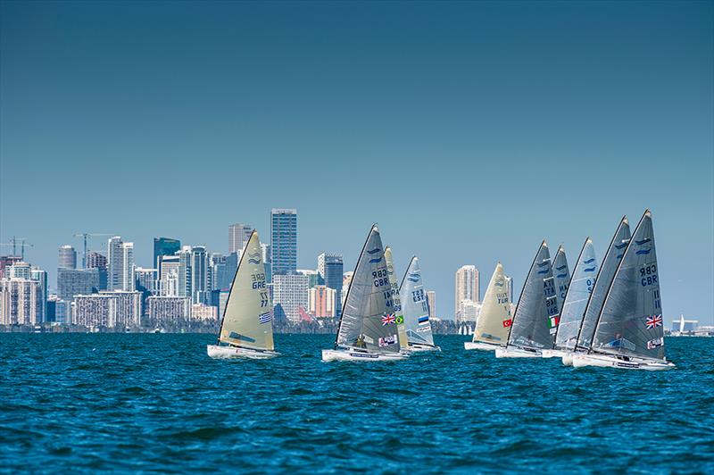 Finn fleet in front of the City of Miami on day 3 at ISAF Sailing World Cup Miami photo copyright Walter Cooper / US Sailing taken at Coconut Grove Sailing Club and featuring the Finn class